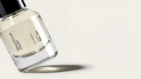 Clear glass bottle with black cap on a light gray background